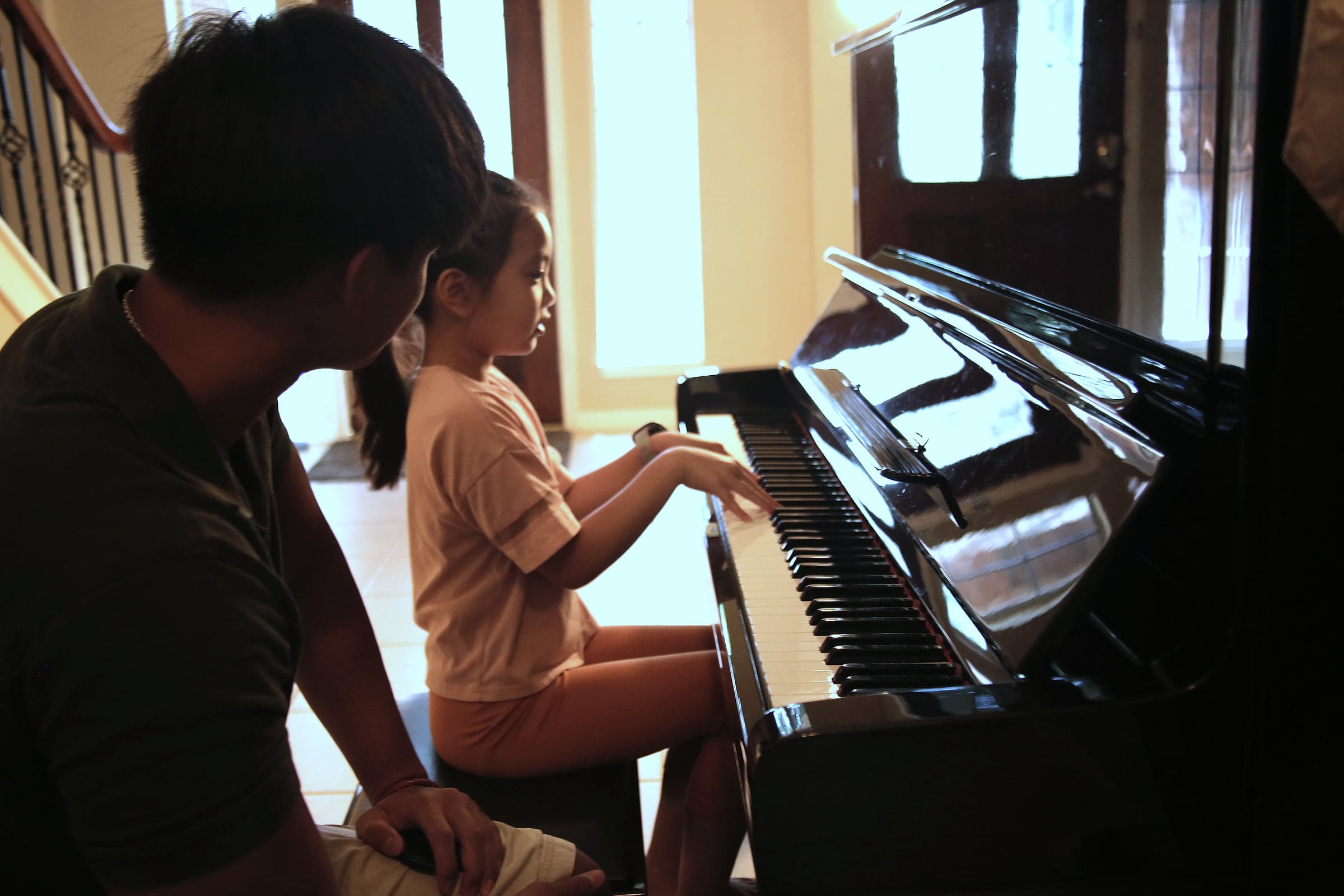 Preston guiding a young student's hands on the keys